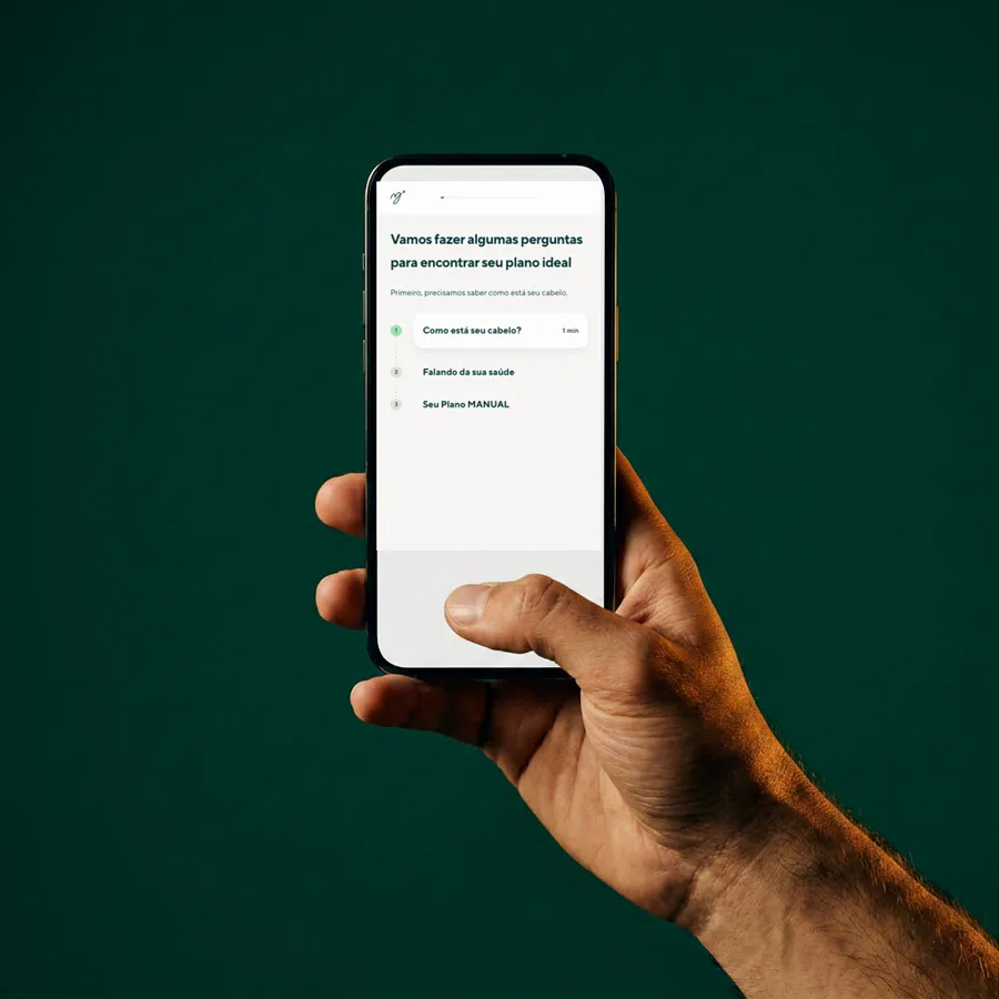 Mão segurando o celular com o questionário da MANUAL